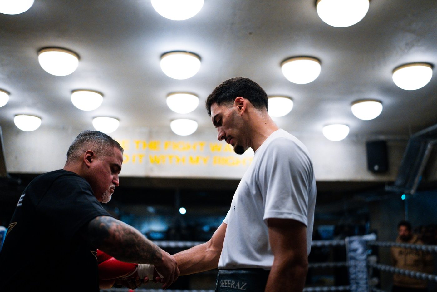 Trainer wrapping the hands of Hamzah Sheeraz before a session